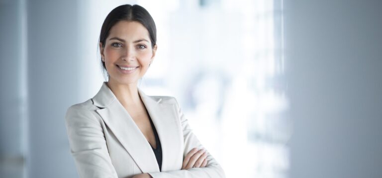 smiling female business leader with arms crossed