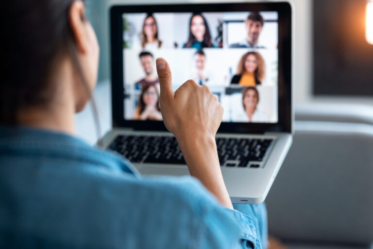 business woman making video call and showing thumb up to laptop on the online briefing while sit on sofa at home.